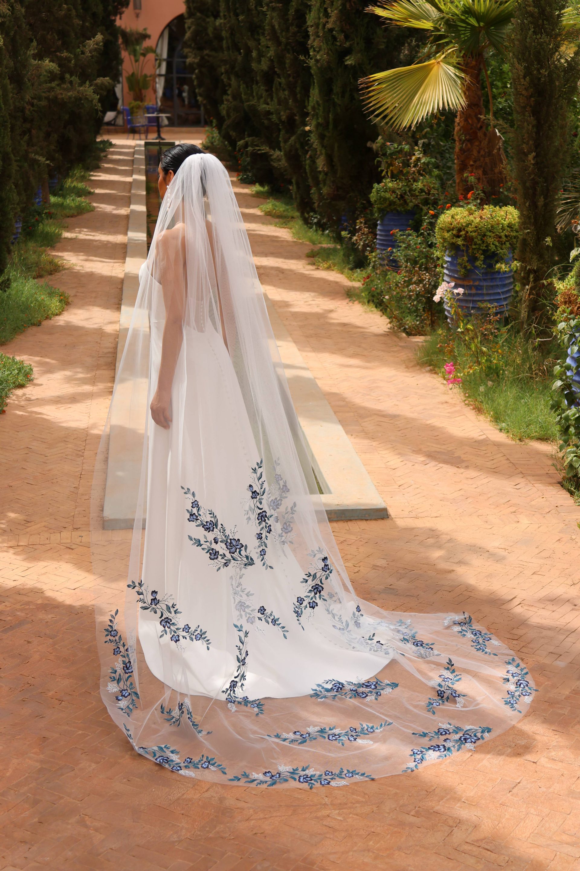 Robe de mariée Azurène avec son son voile bleu iconique.