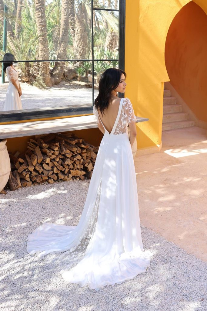 Robe de mariée bohème chic Orée avec dos nu en tulle et longue traîne fluide.