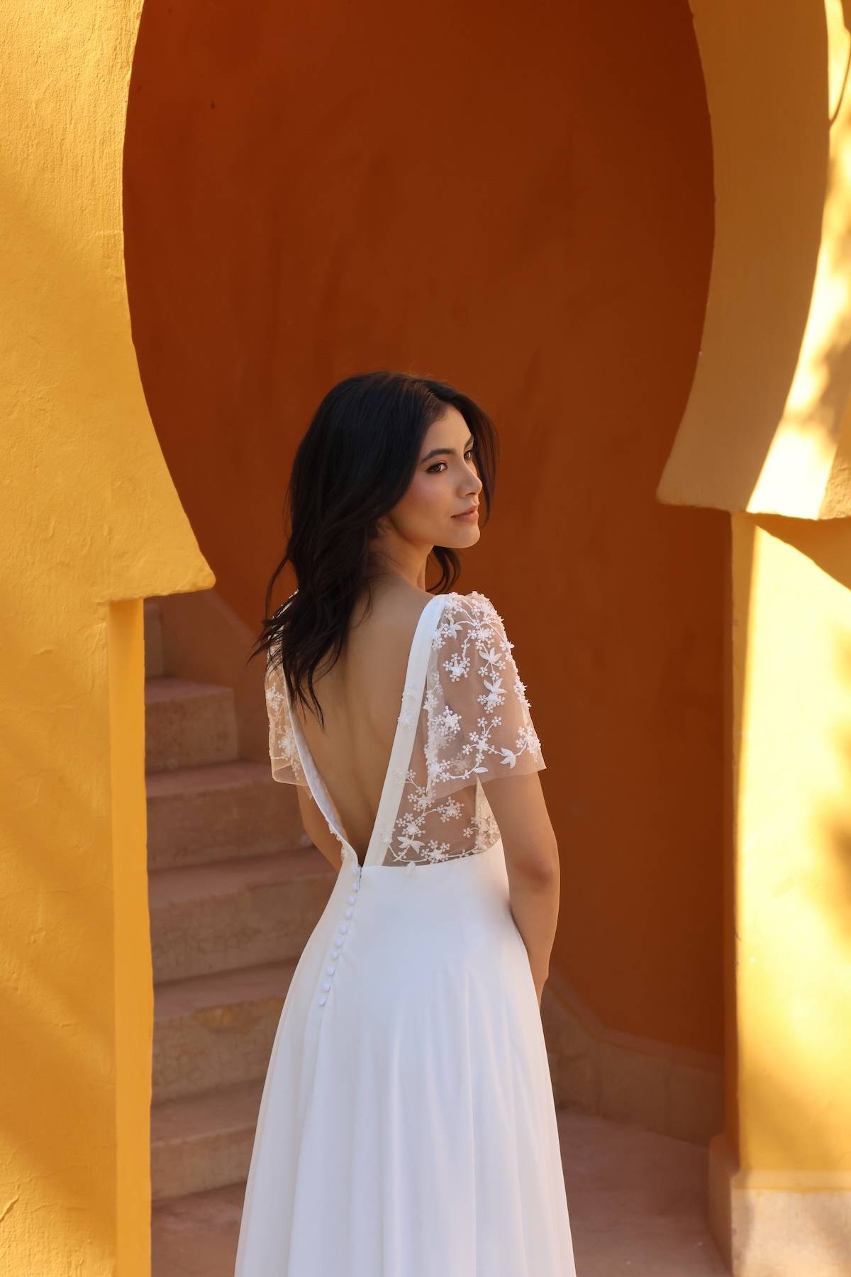 Profil de la robe de mariée bohème chic Orée avec manches transparentes et jupe fluide.