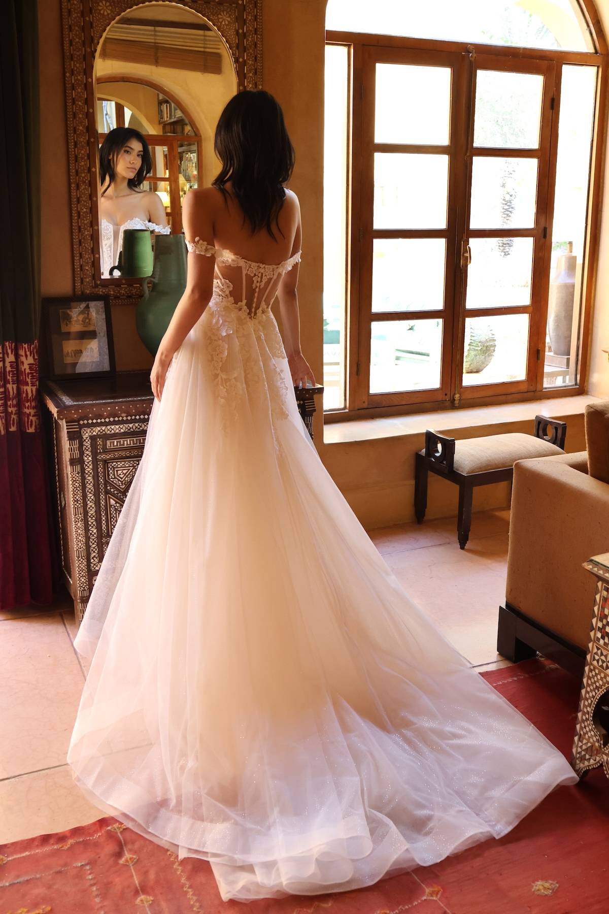 Robe de mariée Rosée d’Or, vue de dos avec une longue traîne en tulle scintillant.
