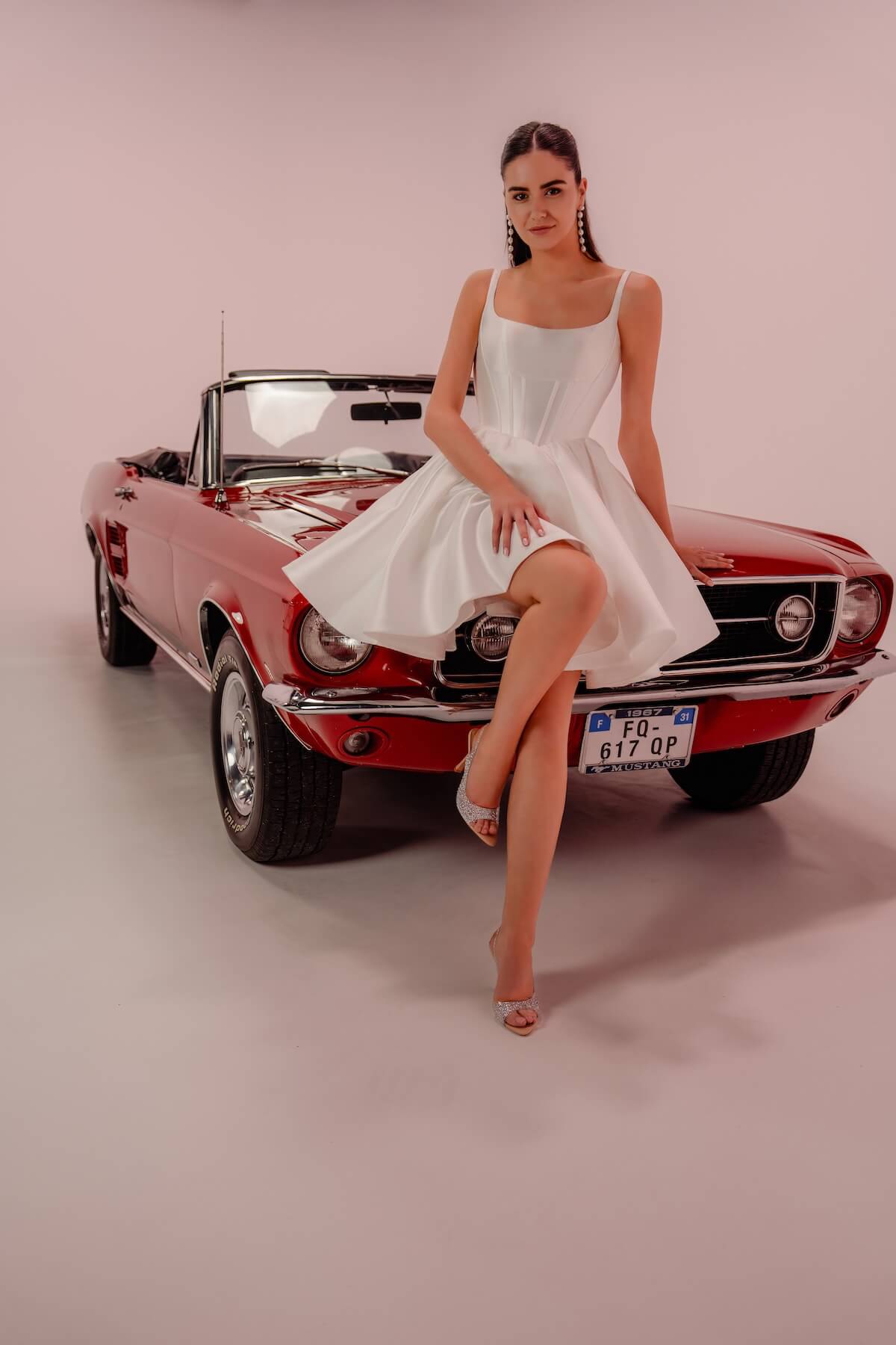 la-valerie-robe-mariee-civile-courte-mikado-voiture-rouge-toulouse La Valérie, robe de mariée civile courte en mikado photographiée assise sur une voiture vintage rouge