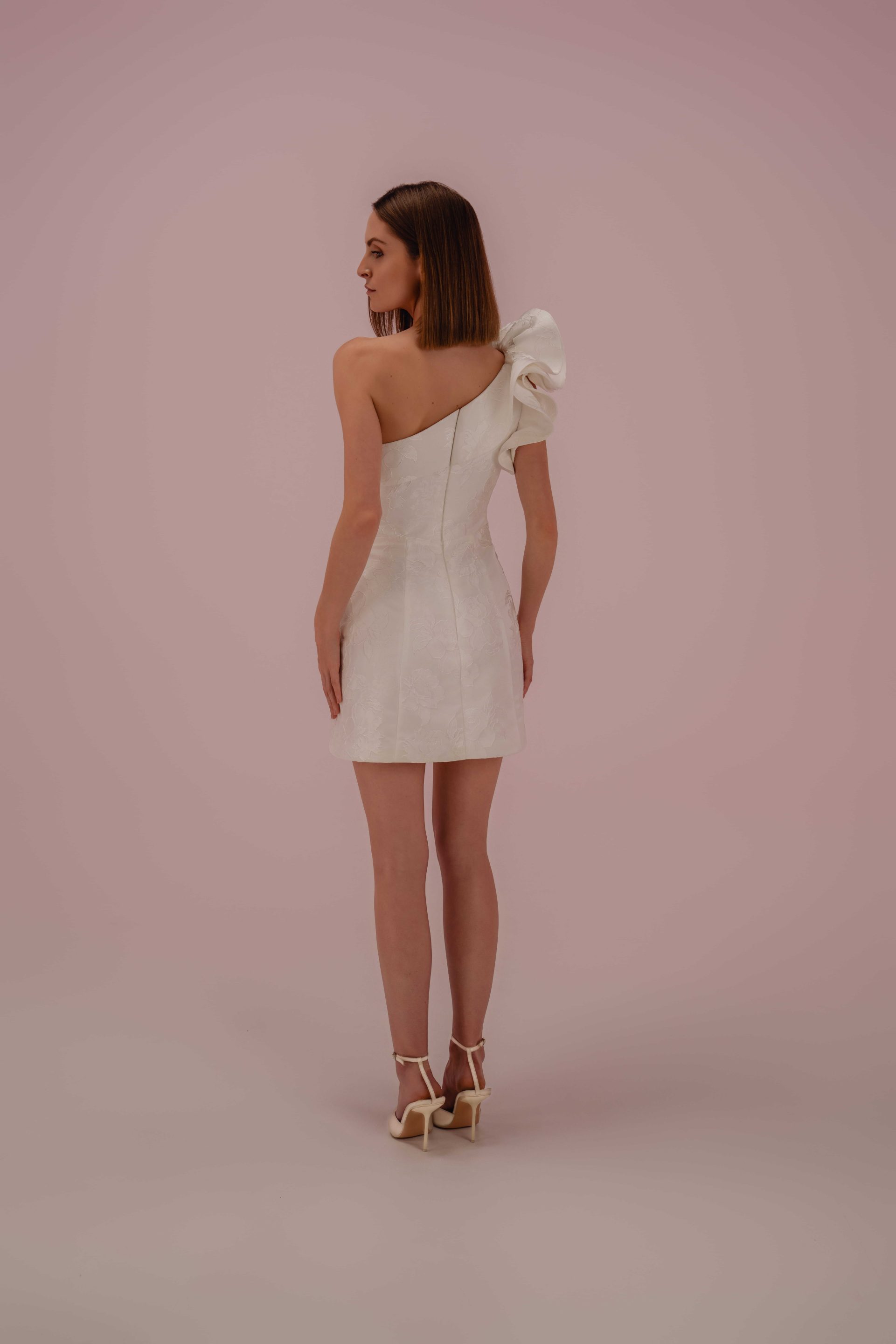 Modèle Diane, robe de mariée courte asymétrique vue de dos avec épaule volantée et coupe structurée