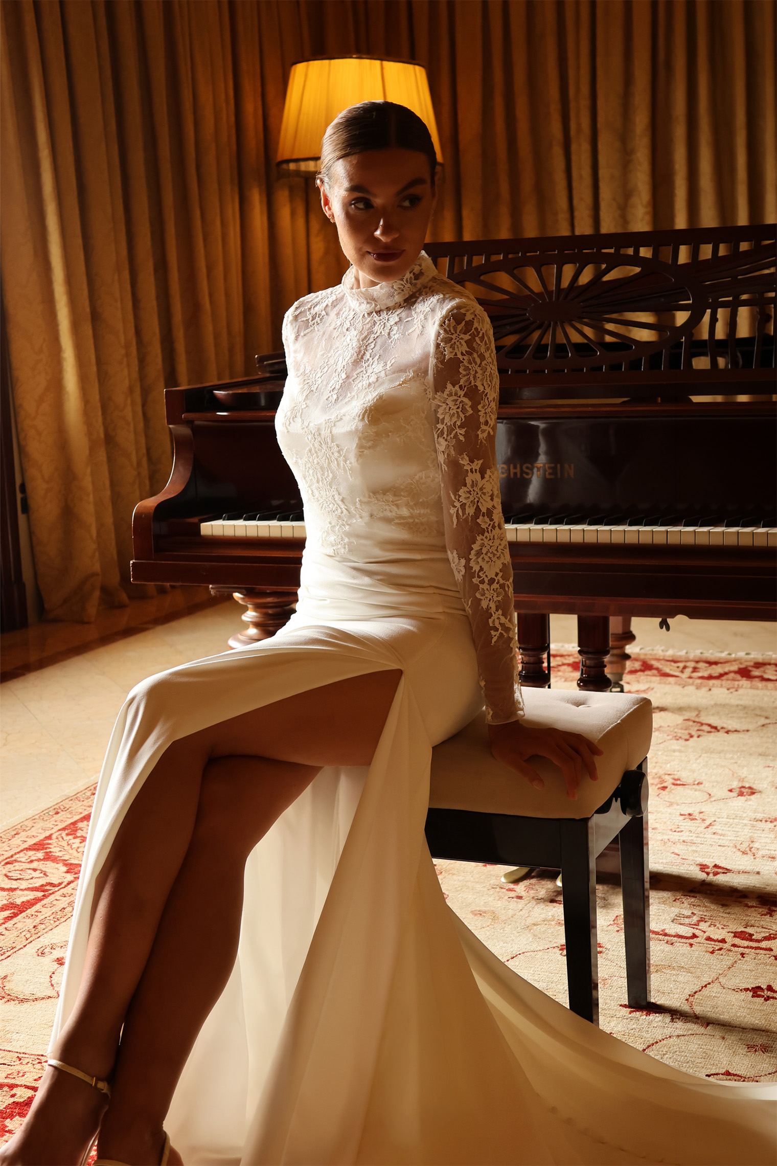 Vue arrière de la robe de mariée Lyséa montrant la longue traîne en crêpe et le dos en dentelle boutonné.