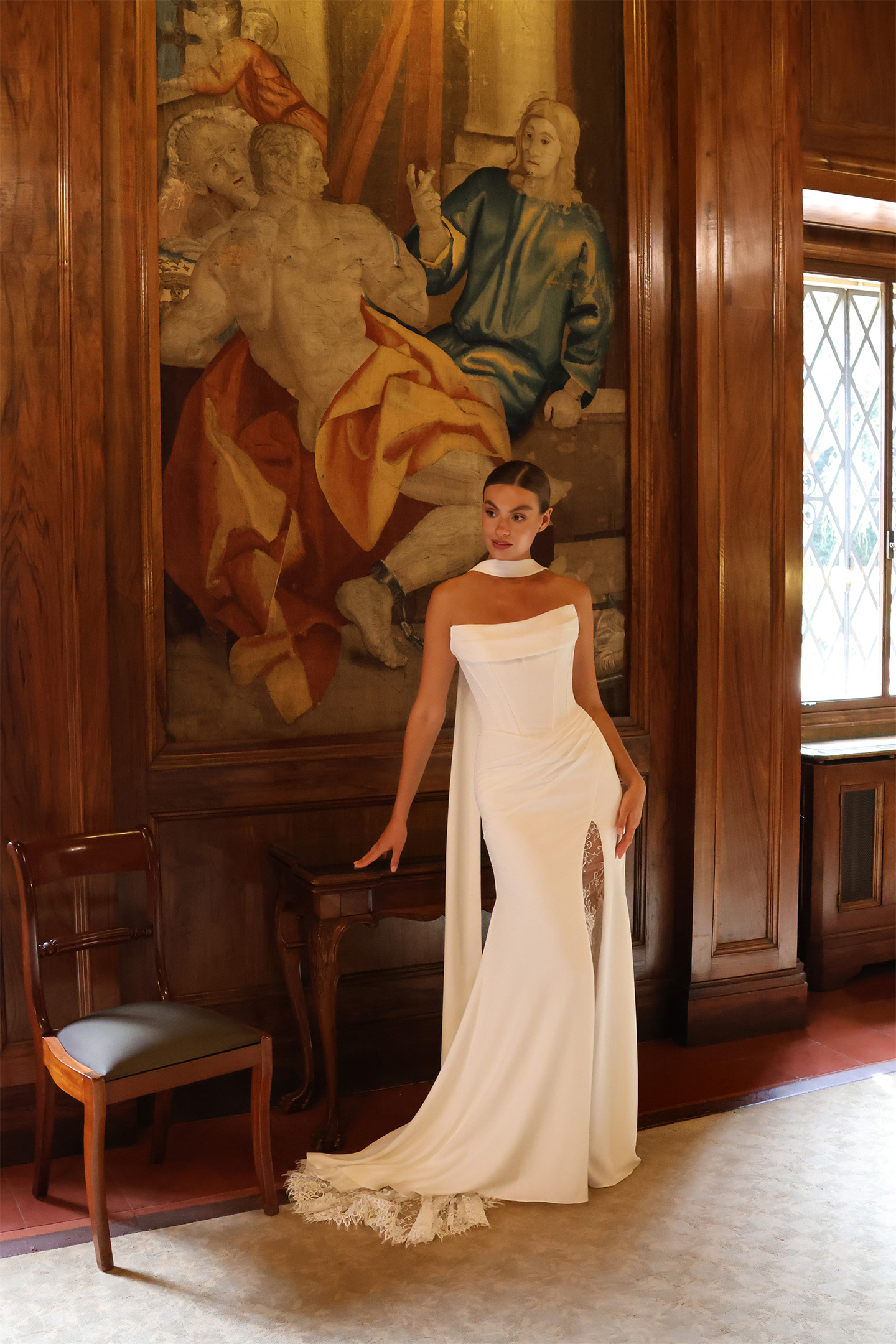 Robe de mariée Ifren avec bustier drapé, fente ornée de dentelle et tour de cou amovible.
