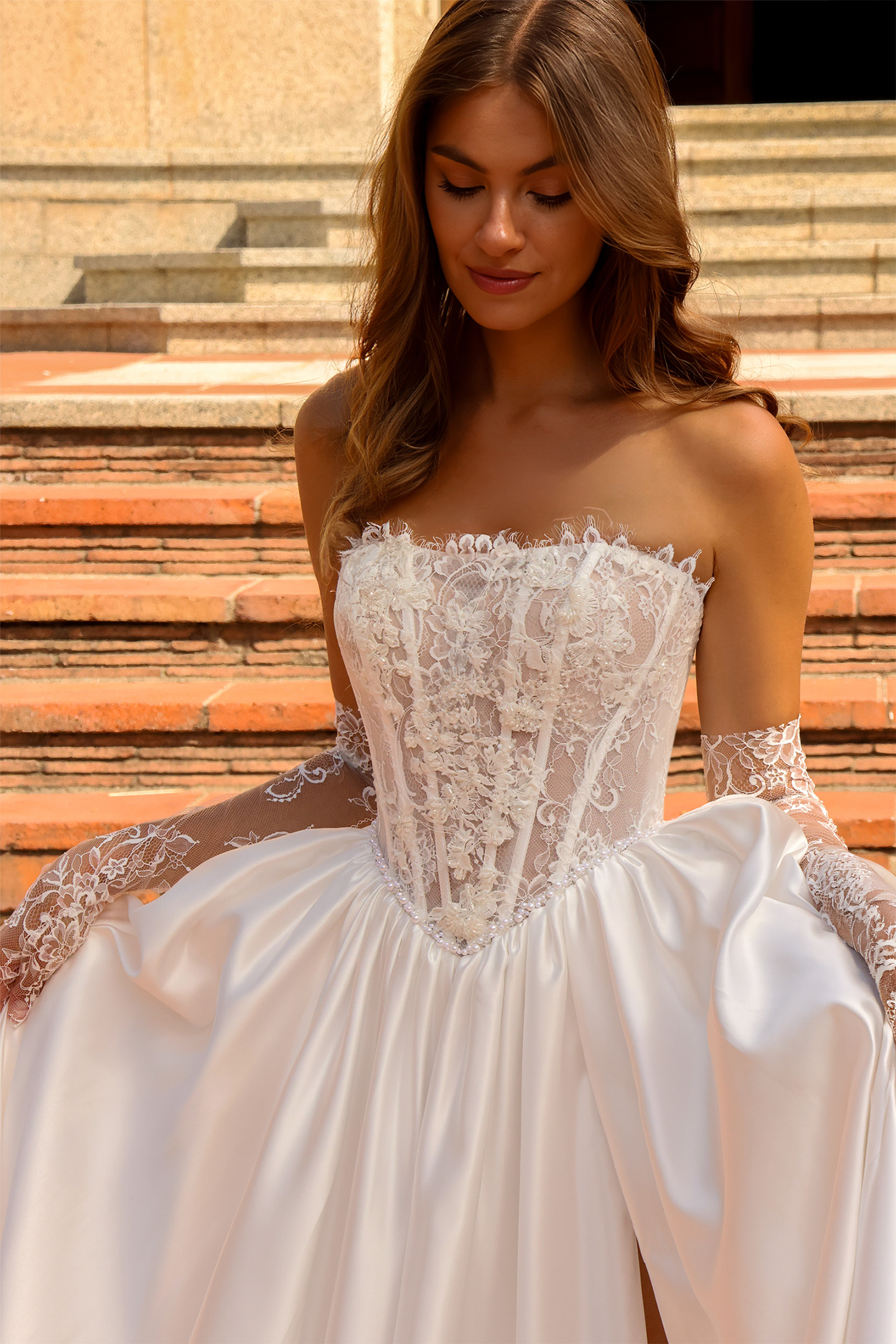 Gros plan sur le bustier en dentelle florale de la robe de mariée Léonie avec manches amovibles.