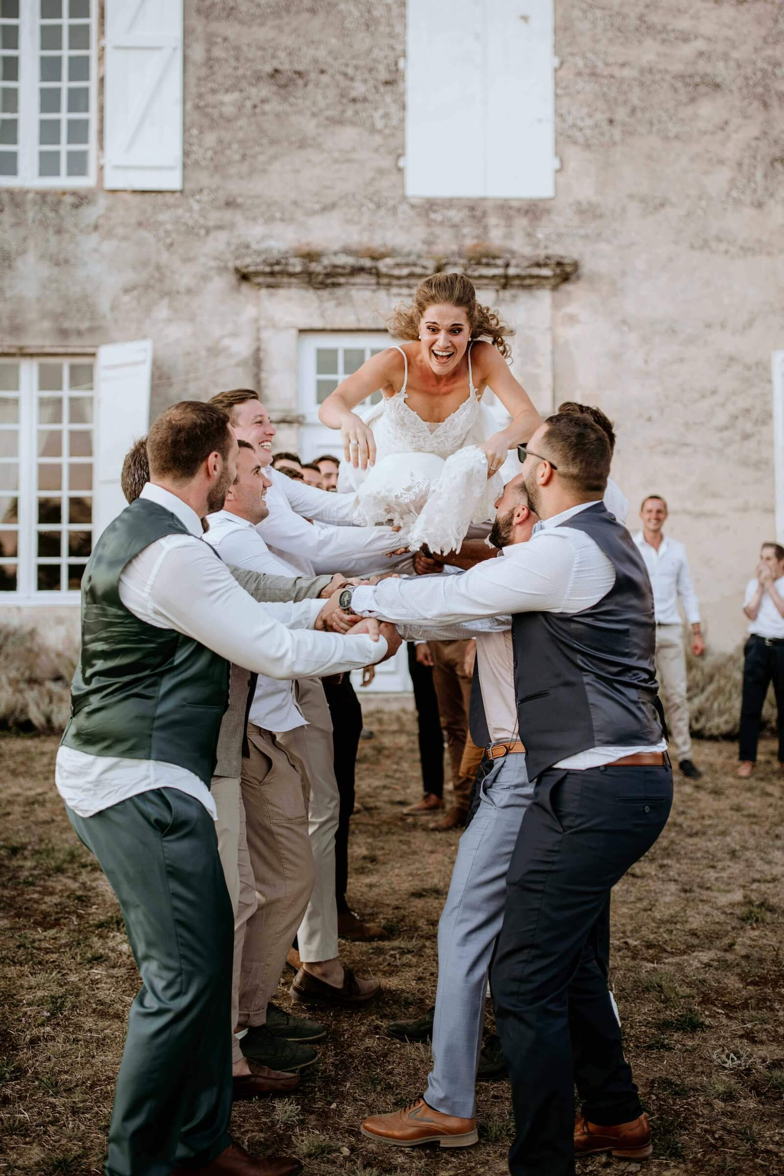 Sylvie sourit, portée par plusieurs proches pendant la journée de son mariage.