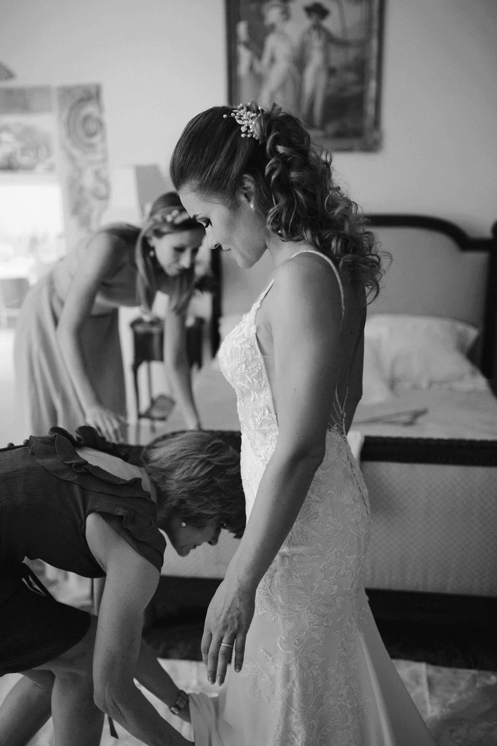 Sylvie pendant l’habillage de sa robe de mariée, photographiée en noir et blanc.