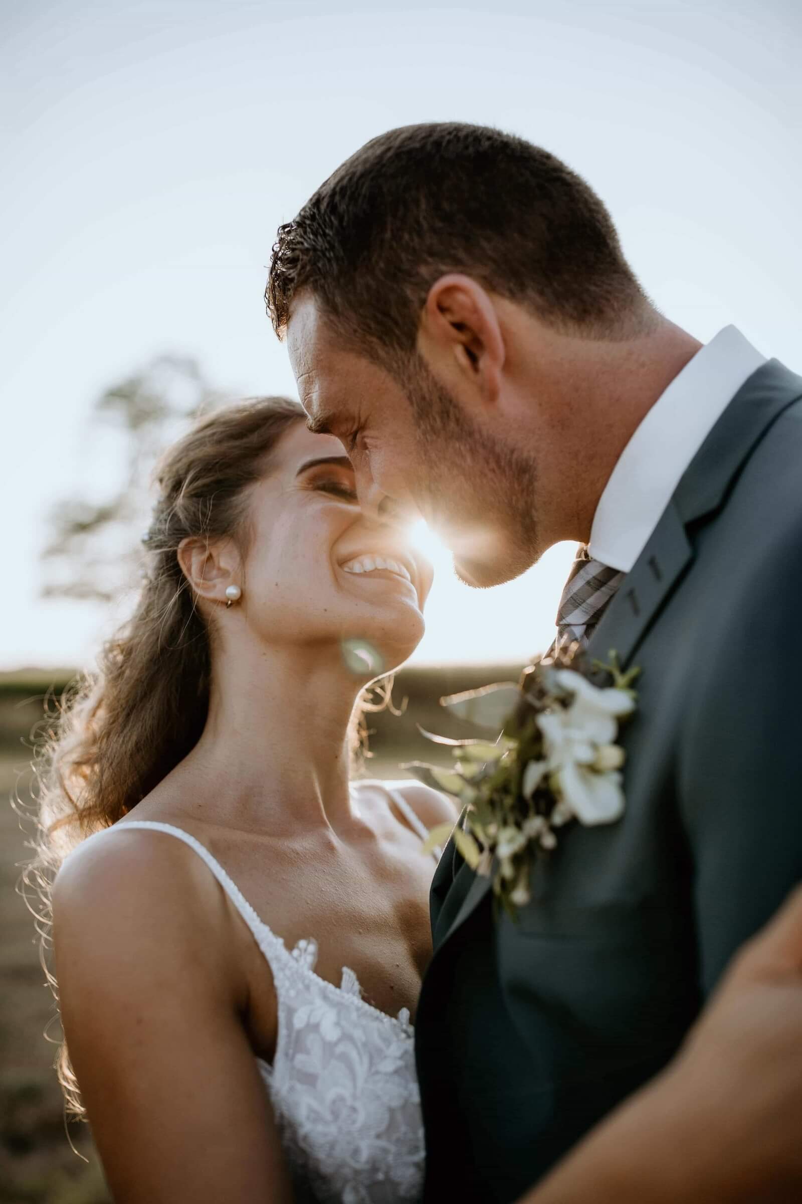 Sylvie et Julien s’embrassent devant une bâtisse aux volets blancs, entourés de leurs proches.